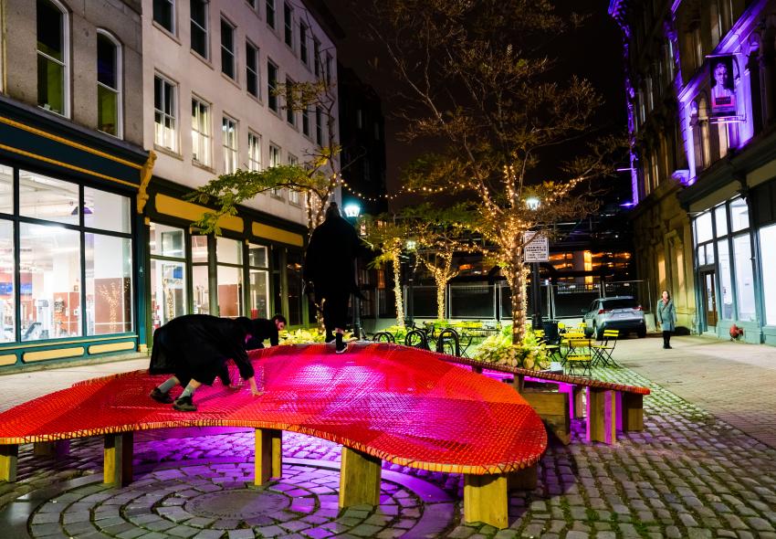 A person climbs up The Blooming Seating at night