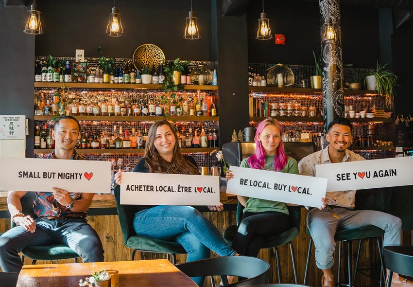 Four Kyo Kitchen & Bar staff holding signs