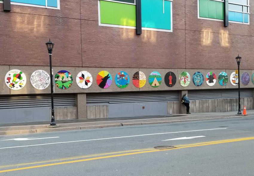 wide shot of 19 murals hanging on the exterior wall of Scotia Square facing Barrington Street