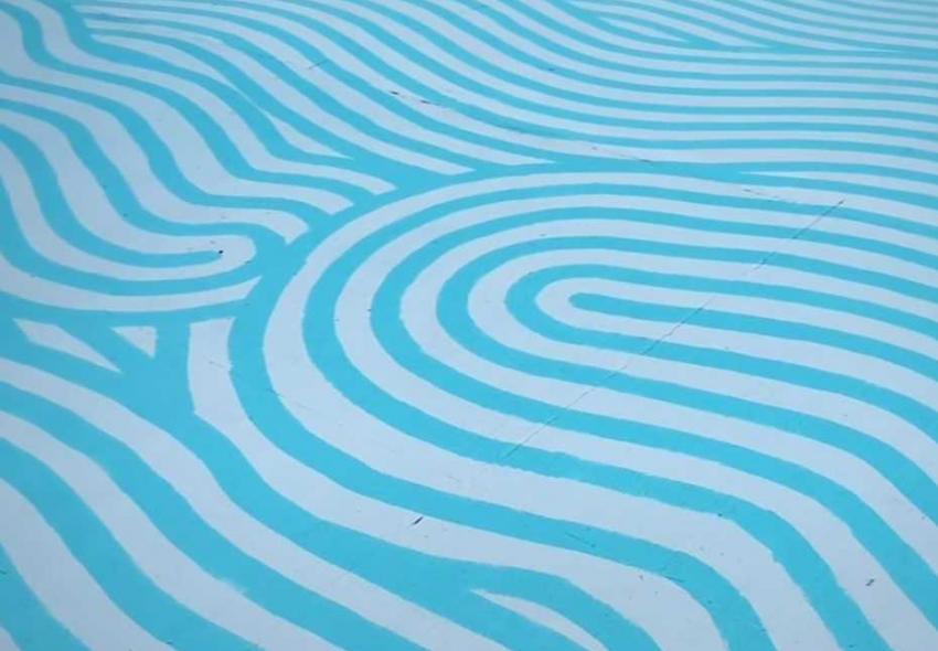 Mural by Bosny on the ground, featuring wavy blue and white alternating lines