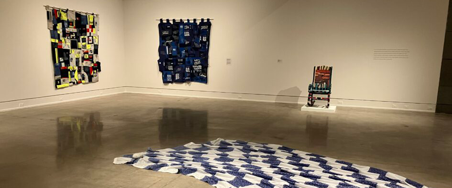 Installation view of textile and fiber art pieces on display in a gallery setting.