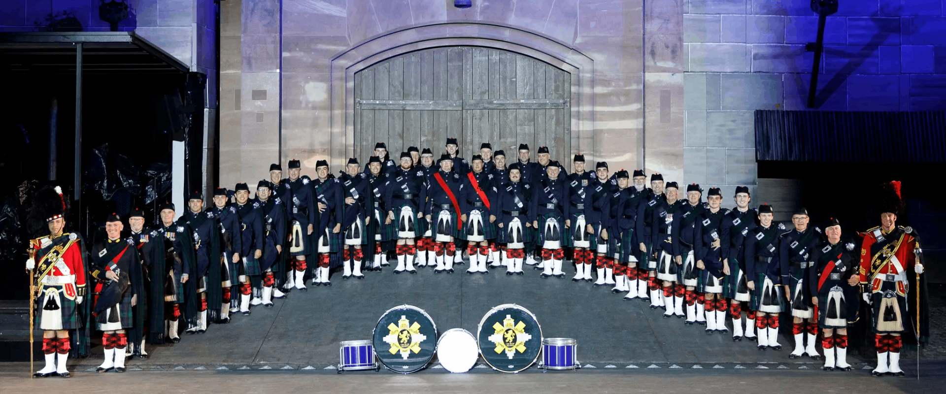 Group photo of the Scots College Old Boys Pipes and Drums dressed in ceremonial dress and kilts.