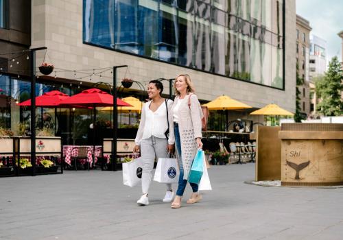 Two women with shopping bags walking downtown