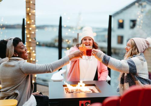 Friends "cheers" to celebrate the holidays with festive cocktails at an event