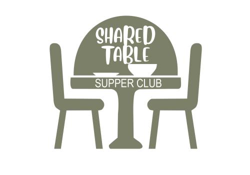 A table with two chairs, plates on top and writing that says Shared table supper club