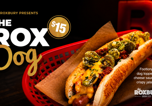 🌭🔥 THE ROX DOG is here! 🔥🌭 A loaded footlong chilli dog topped with cheese sauce and crispy jalapeños - messy, spicy, cheesy, and totally worth it. Grab yours at The Roxbury for just $15!